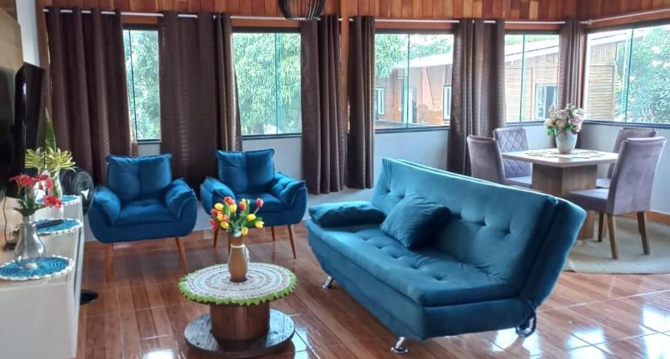 una sala de estar con muebles y ventanas de color azul. en Residencial Recanto Paraíso BC - Cobertura, en Balneário Camboriú