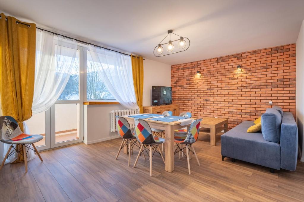 a living room with a blue couch and a table at Apartament Fiński z sauną in Szklarska Poręba