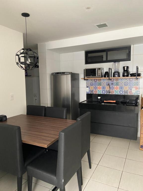 een keuken met een houten tafel en stoelen en een fornuis bij Apart. Dois quartos na Ponta Verde in Maceió