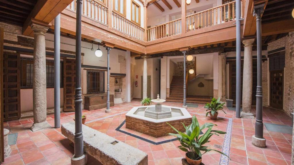 a courtyard with a fountain in the middle of a building at Apartamento Lorenzana by Toledo AP in Toledo