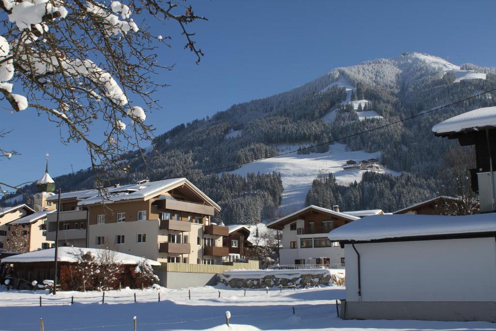 een stad in de sneeuw met een berg op de achtergrond bij Apart Resort Rabl in Westendorf