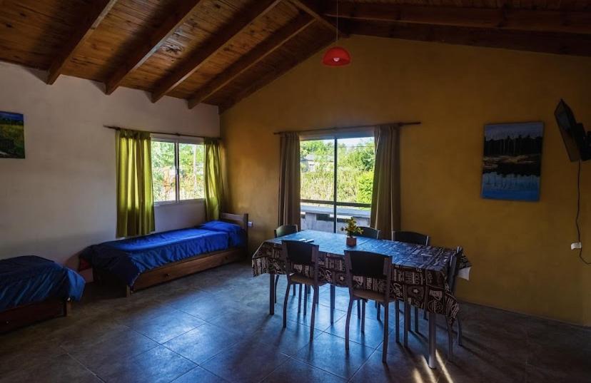 1 dormitorio con mesa, sillas y 1 cama en Posada The Gringos en Villa Yacanto