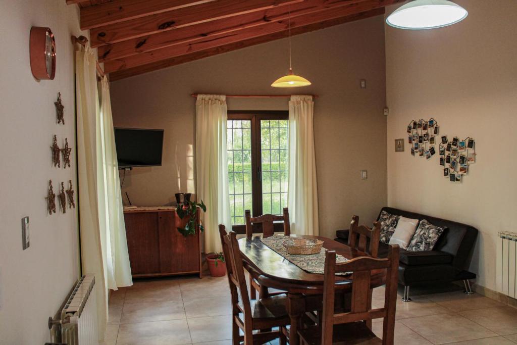 a dining room with a table and a couch at Departamento Parras del Abuelo 2 in Malargüe