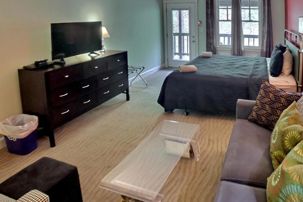 a bedroom with a bed and a dresser with a tv at Bella Paradiso 12 in Eureka Springs