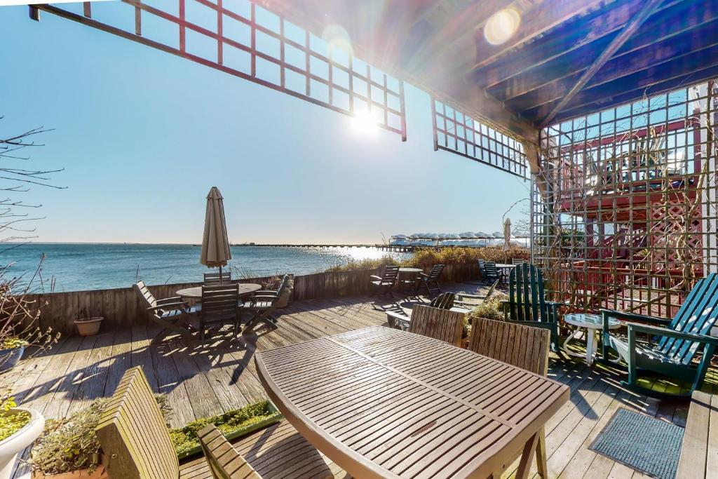 a patio with a table and chairs and the ocean at Commercial Street Retreat in Provincetown