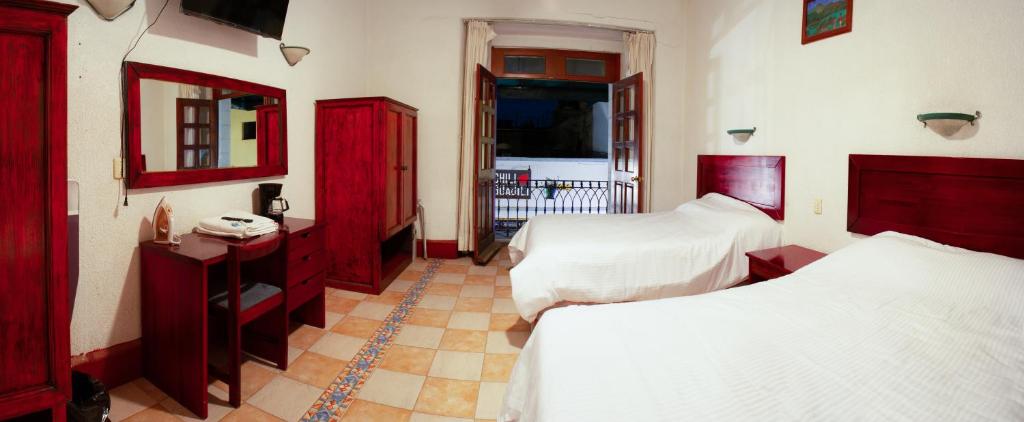 a bedroom with two beds and red cabinets at Hotel Nueva Antequera in Oaxaca City