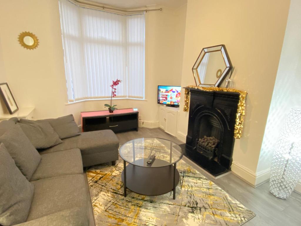 a living room with a couch and a fireplace at Entire 3 Bedroom House- FREE PARKING in Liverpool
