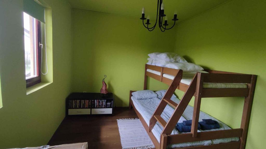 1 dormitorio con 2 literas en una pared verde en Holiday home in Balatonkeresztur 43400, en Balatonkeresztúr