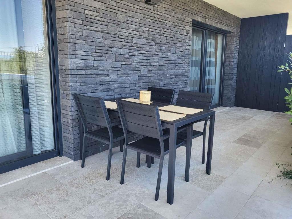 einen schwarzen Esstisch und Stühle auf einer Terrasse in der Unterkunft Apartment in Milcetici - Insel Krk 43321 in Sveti Anton