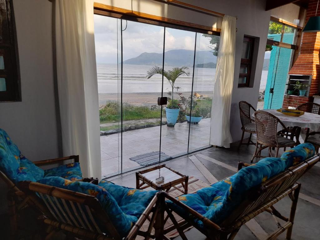 a living room with a couch and a view of the ocean at Casa na praia em São Sebastião in São Sebastião