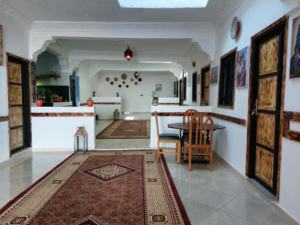 kuchnia i jadalnia ze stołem i dywanem w obiekcie Orca Surf House w mieście Taghazout