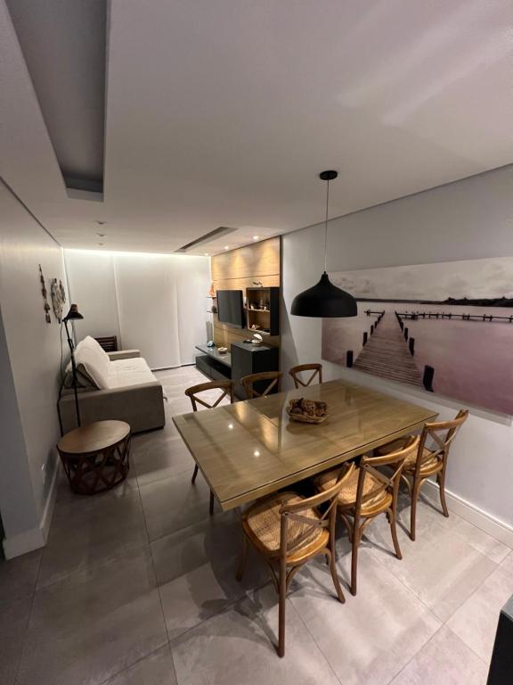 un salon avec une table en bois et un canapé dans l'établissement Apartamento Impecável Completo próximo à praia com Barco Opcional, à Guarujá