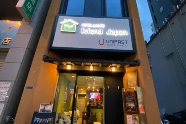 un edificio con un cartel en la parte delantera de una tienda en 2023 NEW OPEN Island Japan Hotel & Cafe, en Tokio