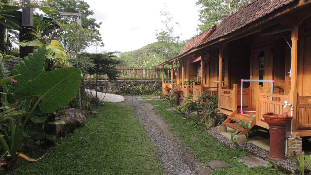 einen Weg neben einem Haus in einem Garten in der Unterkunft Omah Rumba Bata in Ngemplak