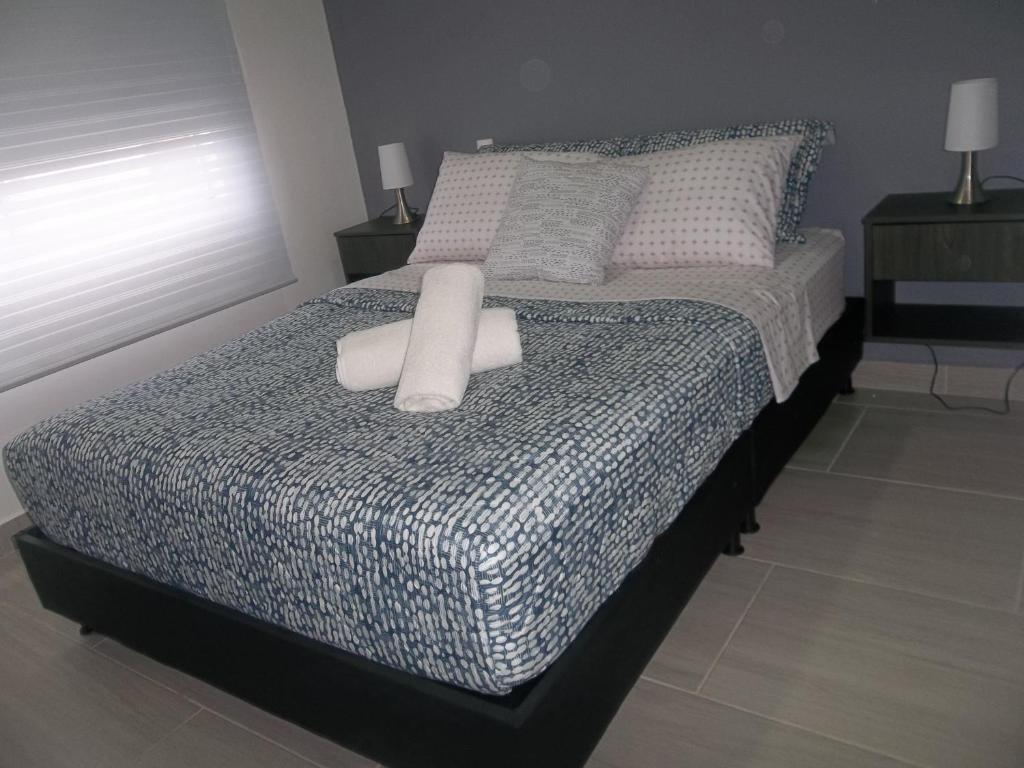 ein Schlafzimmer mit einem Bett mit zwei weißen Kissen in der Unterkunft Apartaestudio en Pereira con vista al viaducto - Beatiful apartment with city view in Pereira