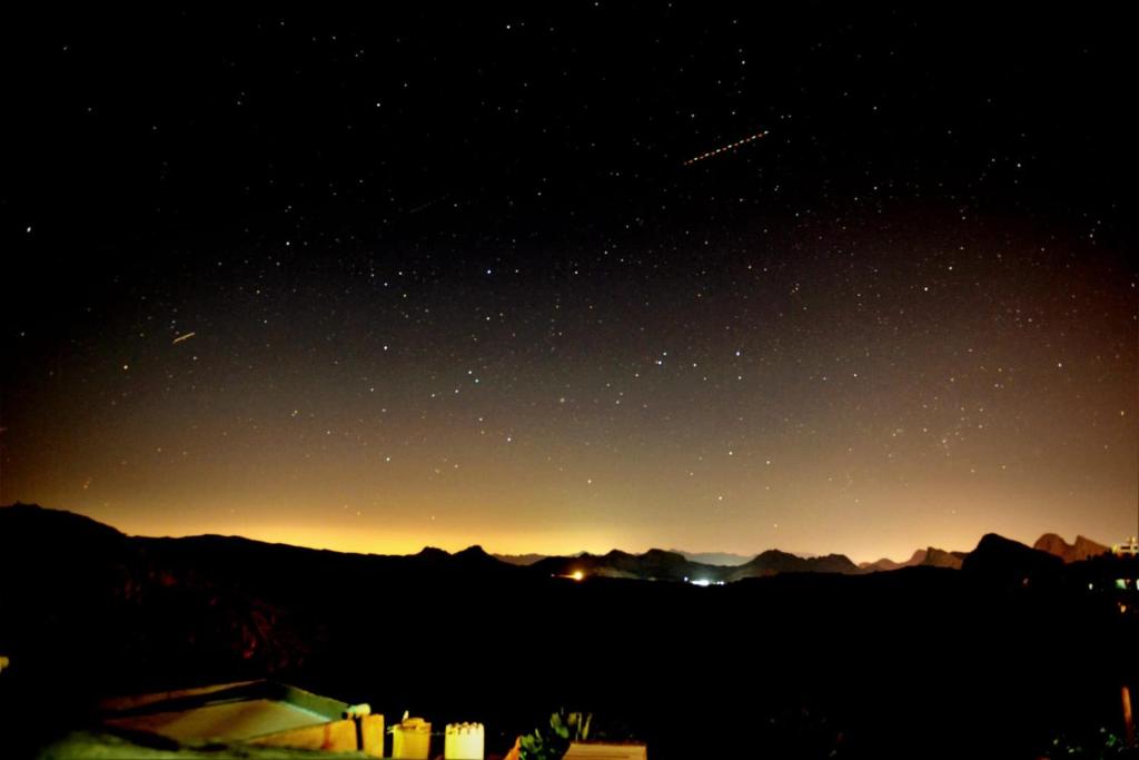 a starry night with a view of the mountains at Al Misfah Hospitality Inn in Misfāh