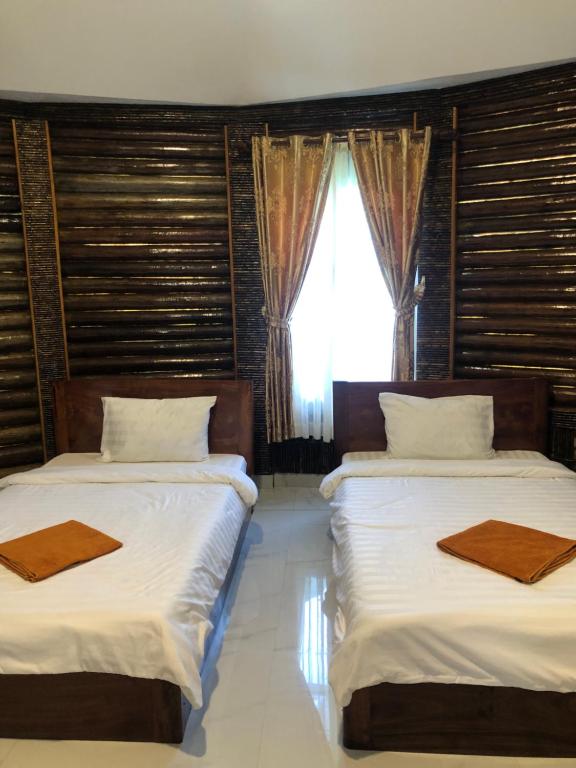 two beds in a room with a window at M'pay Bay Guesthouse in Koh Rong Sanloem