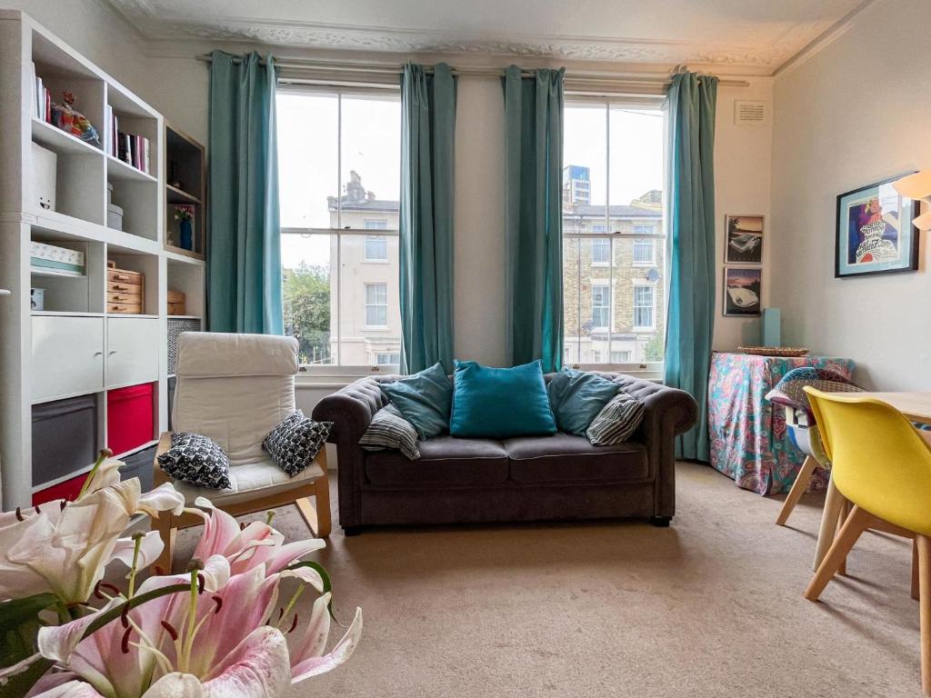 a living room with a couch and two windows at Beautiful 3BD Flat in Archway London in London