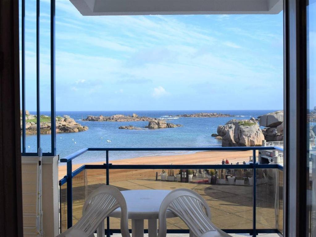 a balcony with two chairs and a view of the ocean at Appartement Trégastel, 3 pièces, 4 personnes - FR-1-368-29 in Trégastel
