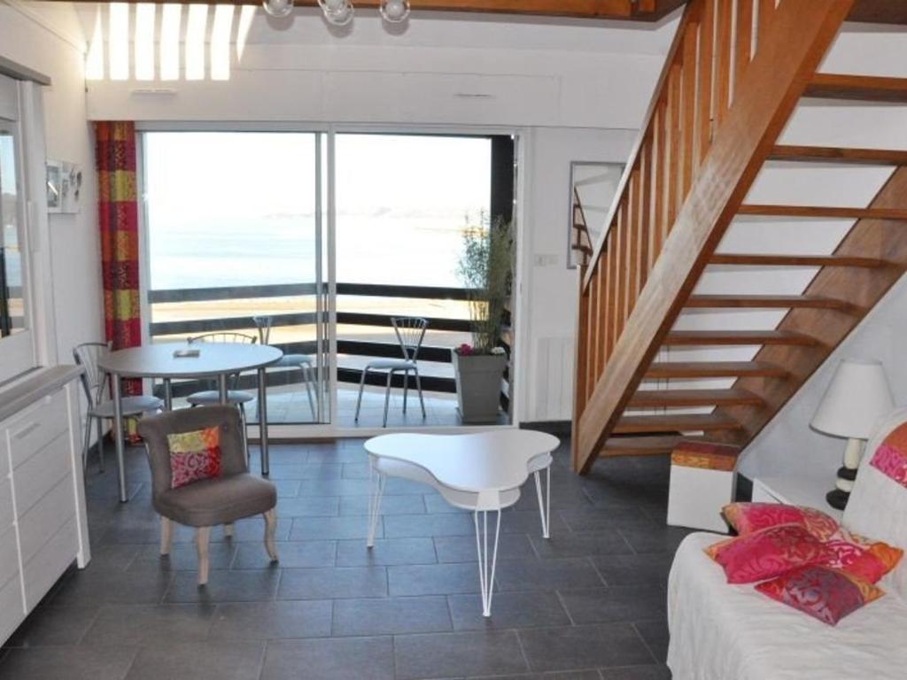 uma sala de estar com uma escada e uma mesa e cadeiras em Appartement Perros-Guirec, 1 pièce, 4 personnes - FR-1-368-75 em Perros-Guirec
