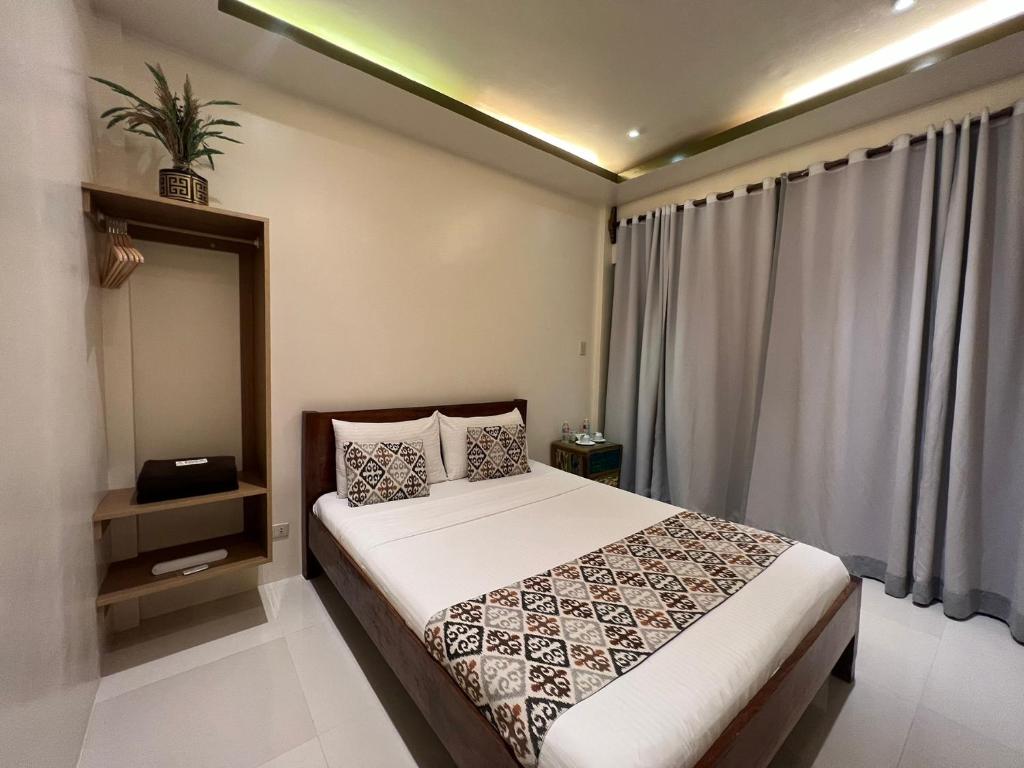 um quarto com uma cama e uma grande janela em Bulul Garden Resort em El Nido
