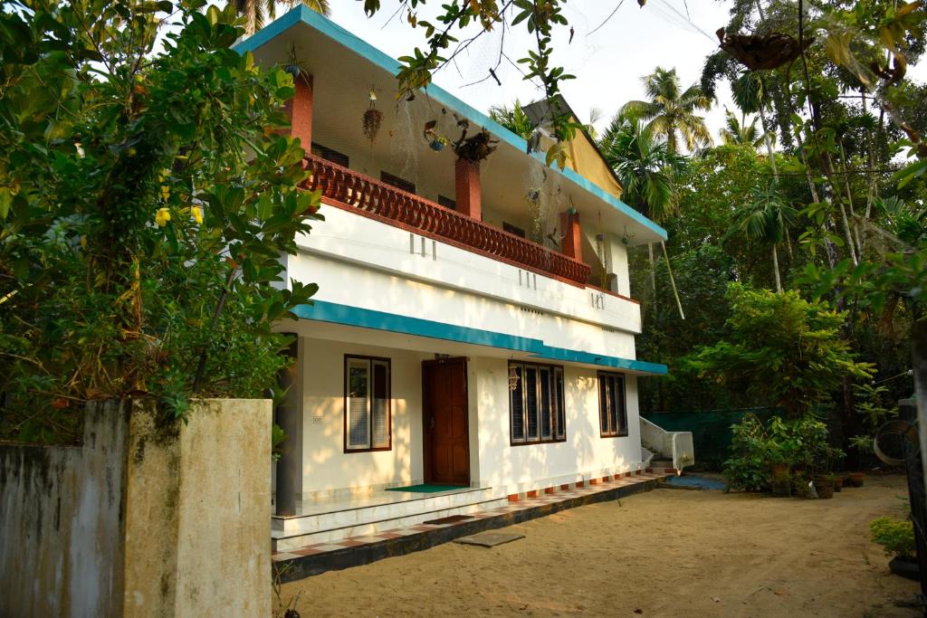 a white house with a blue roof at Dhakshina Homestay in Cochin