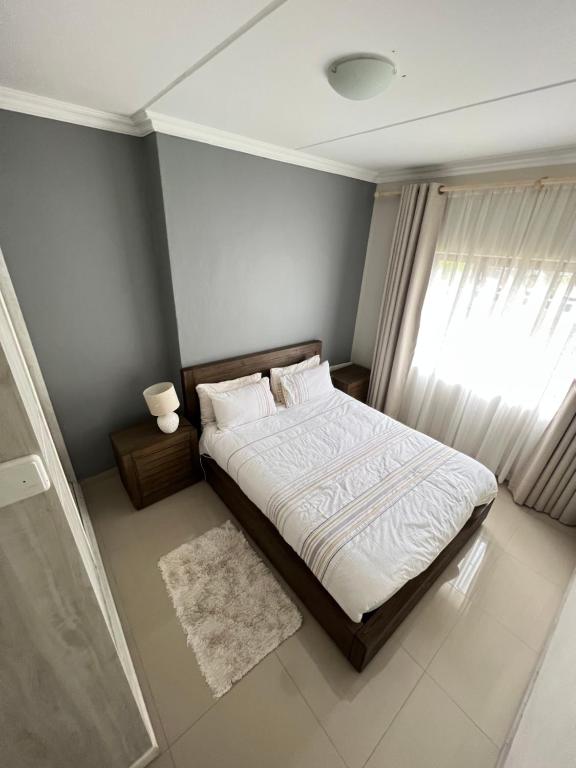 a bedroom with a bed and a window at The Escape Haven in Sandton
