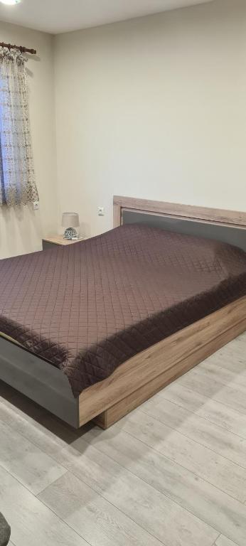 un letto con struttura in legno in una stanza di ЗАРА a Ruse