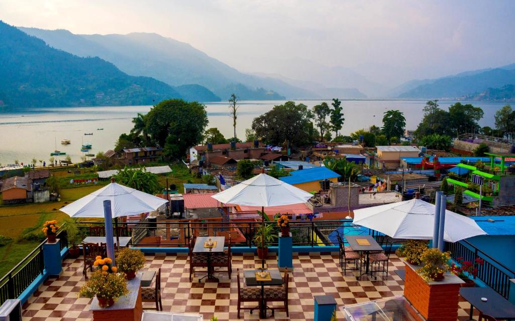 a view of a resort with tables and umbrellas at Hotel Adam in Pokhara