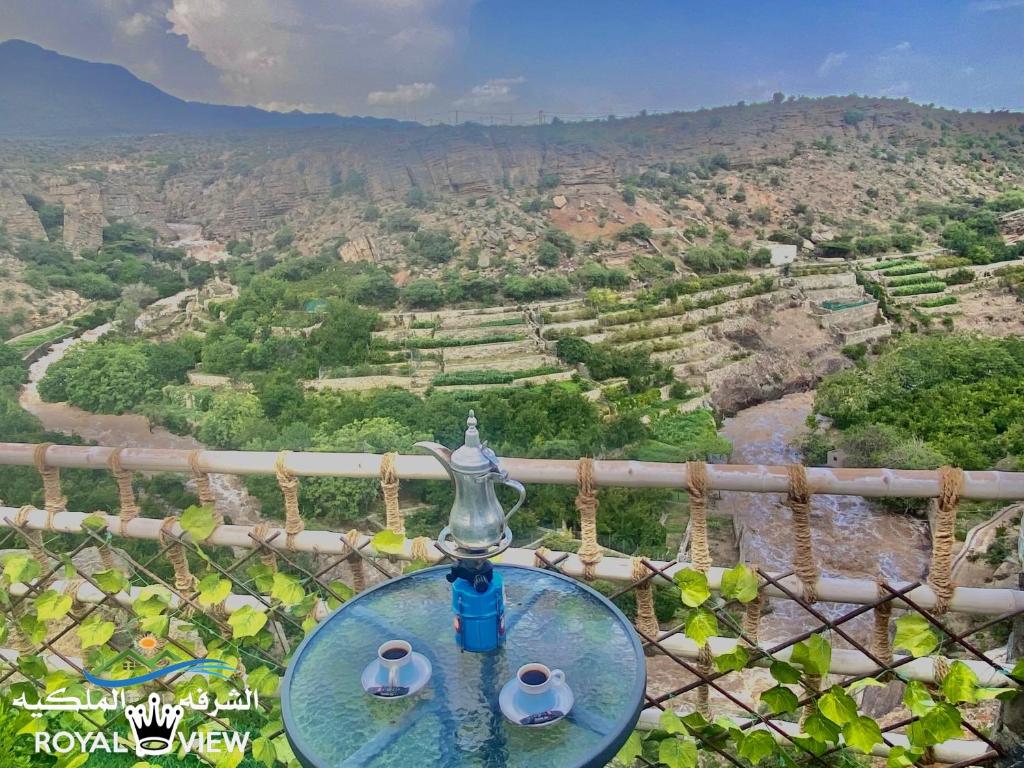 a glass table with a view of a valley at Royal view Villa استراحة الشرفة الملكية in Sayq