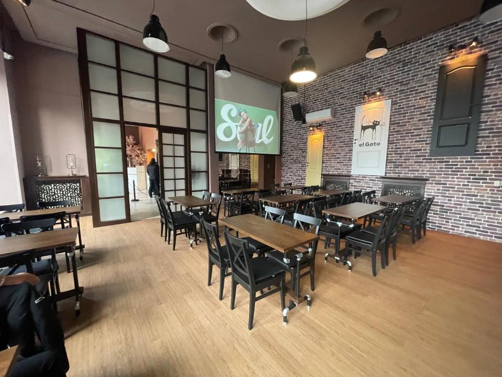 um restaurante com mesas e cadeiras e uma parede de tijolos em Hotel Continental em Iaşi