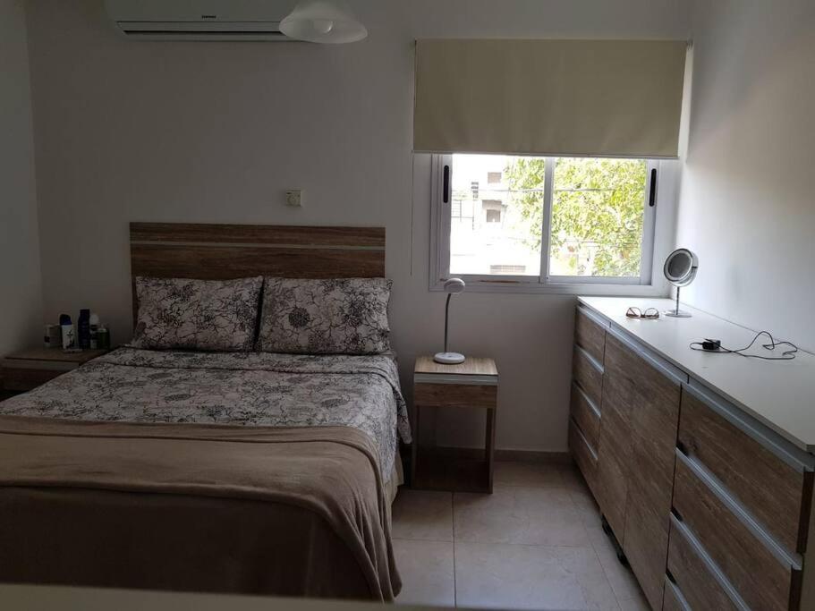 1 dormitorio con 1 cama con tocador y ventana en Confortable departamento con cochera, hasta 4 personas en San Juan