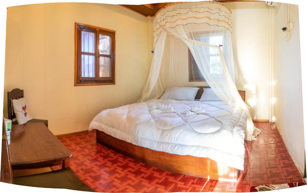 - une chambre avec un lit et une moustiquaire dans l'établissement Chanhthida Riverside Guesthouse and The River Front Restaurant, à Ban Khon