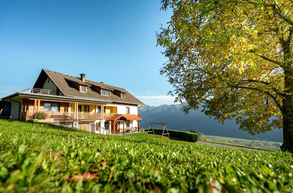 une maison sur une colline avec des montagnes en arrière-plan dans l'établissement Hauserhof am Goldberg, à Dellach