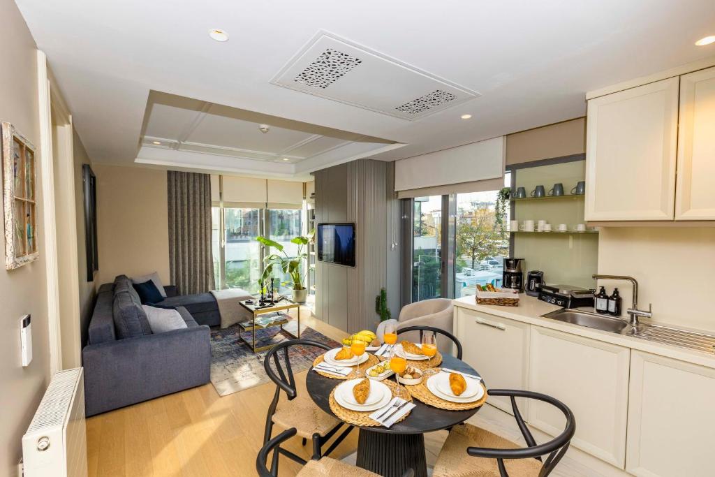 een keuken en een woonkamer met een tafel en stoelen bij Acibademflat in Istanbul