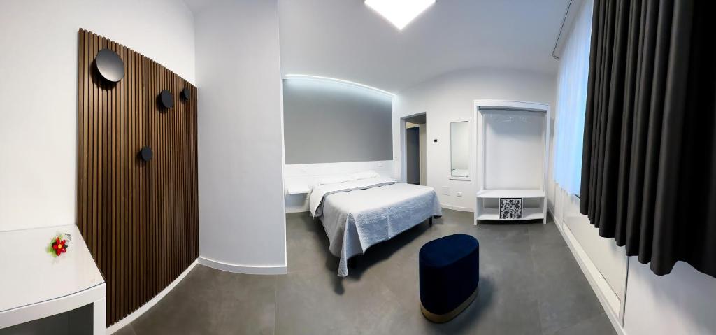 a bedroom with a white bed and a blue stool at B & B Dal Barone in Sulmona