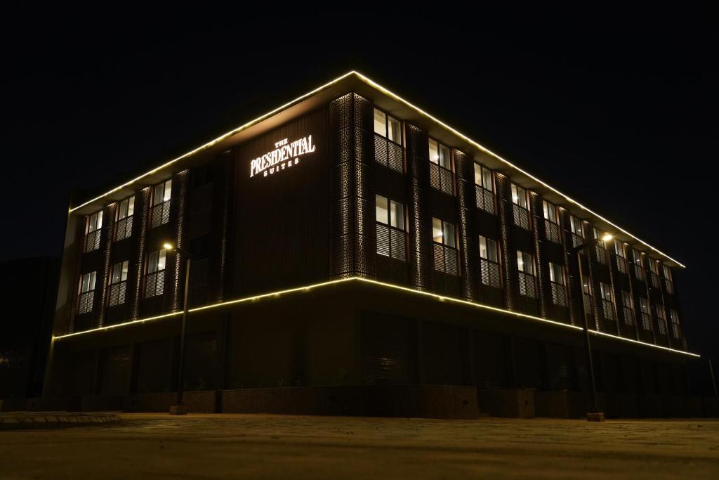 a building with a sign on the side of it at night at The Presidential Suites in Bhuj