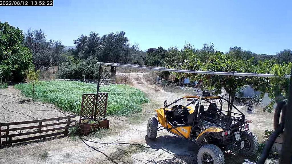 a yellow atv parked under a canopy in a field at TRADITIONAL HOUSE MARIA in Azoyirás