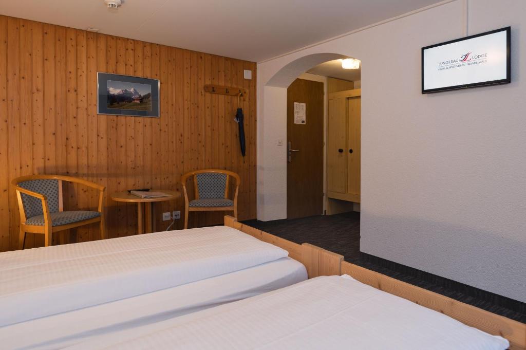 Postel nebo postele na pokoji v ubytování Jungfrau Lodge, Swiss Mountain Hotel