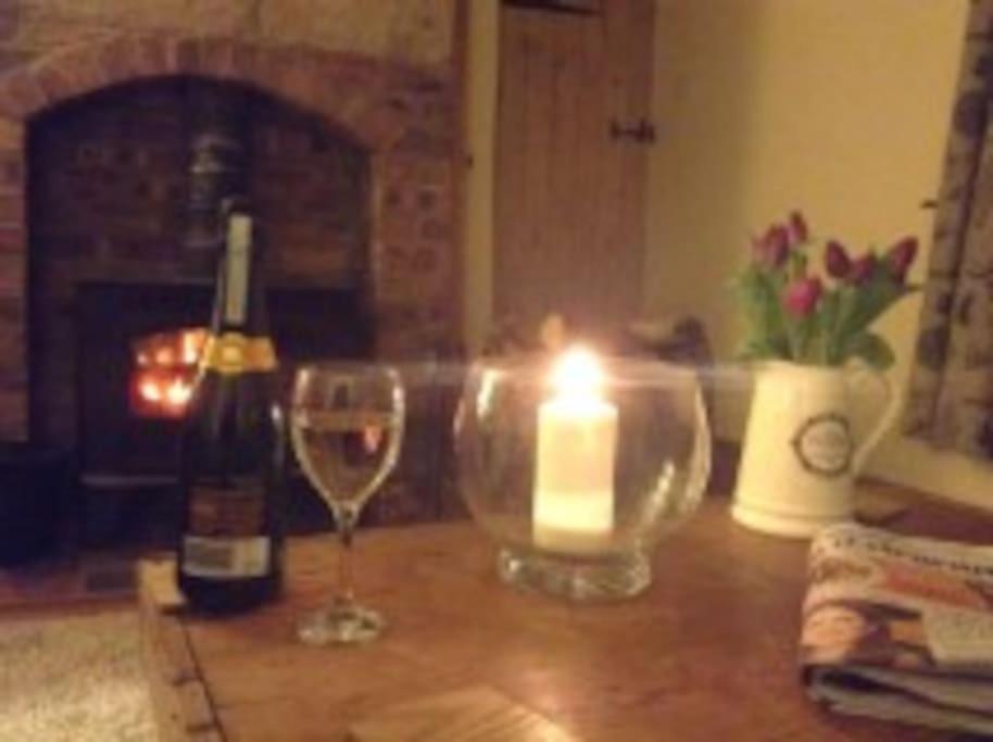 a candle and a bottle of wine and a glass at Beautiful Stone Riverside Cottage in Waterfall