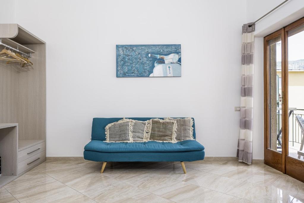 einen blauen Stuhl in einem Zimmer mit einem Bild an der Wand in der Unterkunft Parsano Suite in Sorrent