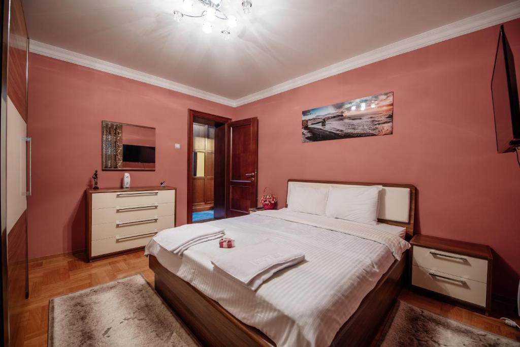 1 dormitorio con 1 cama grande y paredes rojas en Loft2, en Kolašin