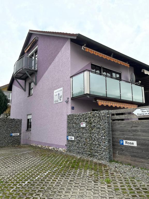 ein lila Haus mit einem Balkon an der Seite in der Unterkunft Appartementhaus Silke in Bad Füssing