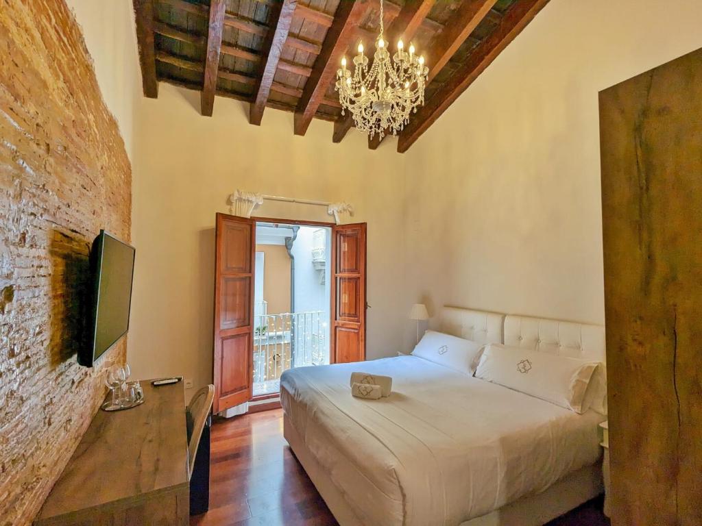 a bedroom with a bed and a chandelier at Catalina Suites in Valencia