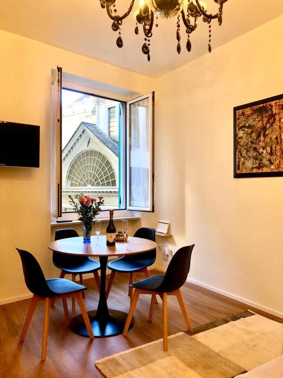 a dining room with a table and chairs and a window at Palazzo Penco Apartment in Genoa