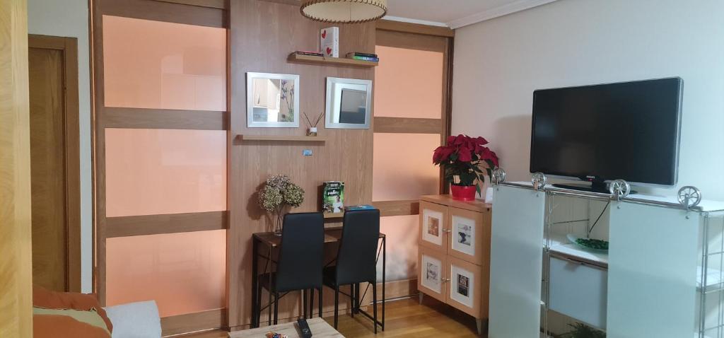 un soggiorno con tavolo e TV a schermo piatto di Cristo22 Apartamento recién reformado con parking propio a Vigo