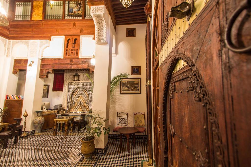 um corredor com uma porta de madeira e uma sala de jantar em Dar Labchara em Fez