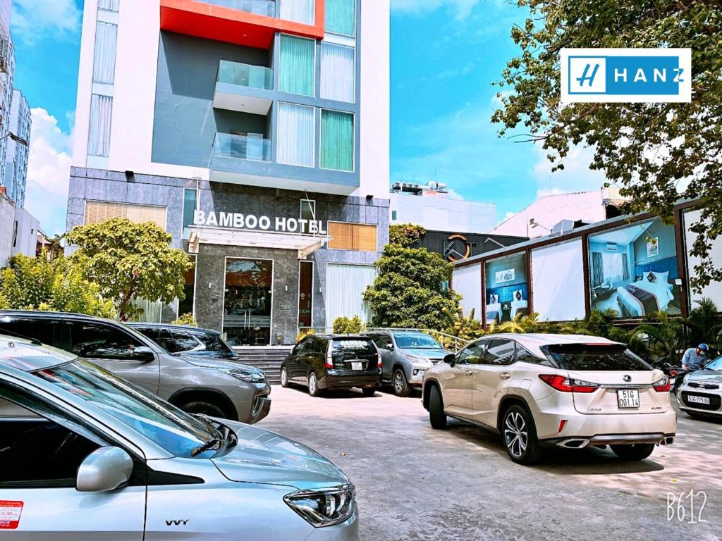 parking z samochodami zaparkowanymi przed budynkiem w obiekcie HANZ Premium Bamboo Hotel w Ho Chi Minh