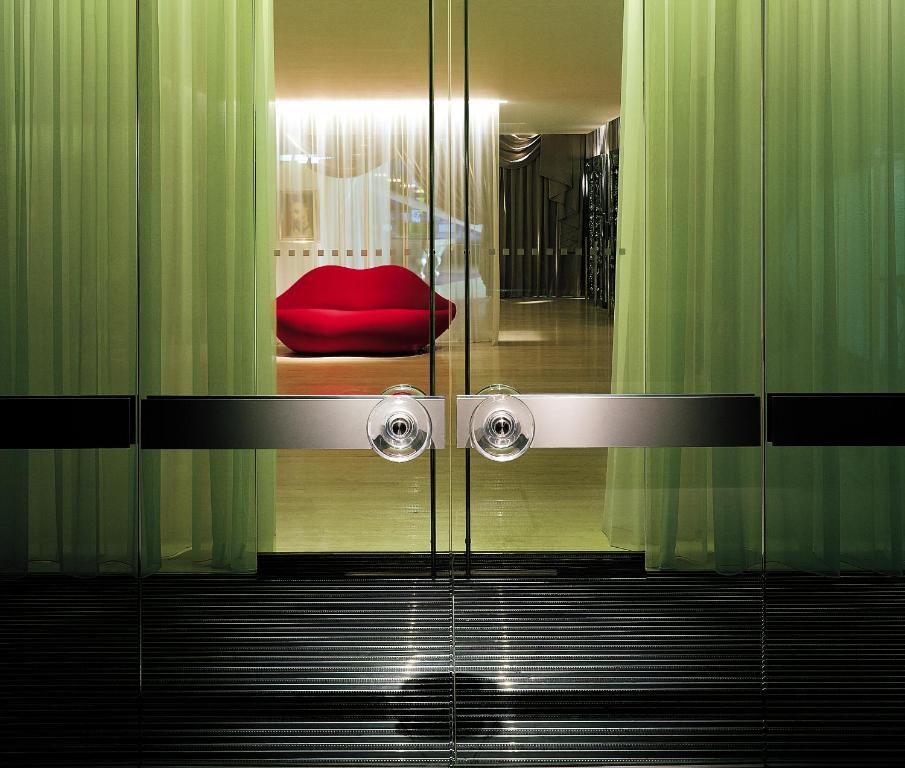 uma cabina de duche em vidro com um assento vermelho num quarto em Sanderson London em Londres