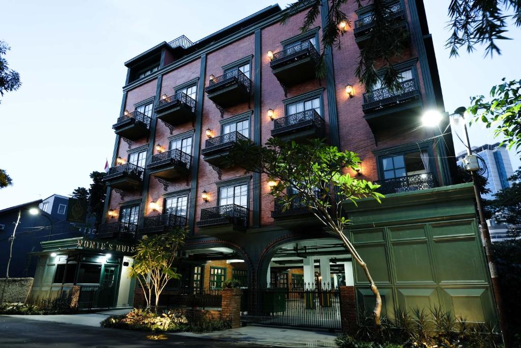 a large brick building with balconies on a street at Nonies Huis Cibubur in Kalimanggis